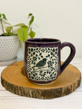 Load image into Gallery viewer, #008 - 16 oz. Purple mug with a bird and flower pattern. Unglazed clay where pattern is
