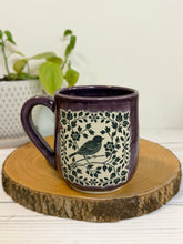 Load image into Gallery viewer, #008 - 16 oz. Purple mug with a bird and flower pattern. Unglazed clay where pattern is
