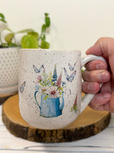 Load image into Gallery viewer, #028 - 14 oz. White speckled mug with watering can and flowers
