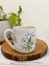 Load image into Gallery viewer, #029 - 16 oz. White speckled mug with watering can and flowers
