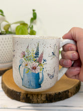 Load image into Gallery viewer, #029 - 16 oz. White speckled mug with watering can and flowers
