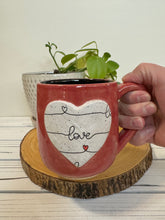 Load image into Gallery viewer, #011 - 16 oz. Red mug with love pattern on a stand out white Matte heart. Black inside *see note
