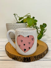 Load image into Gallery viewer, #014 - 16 oz. White speckled mug with heart pattern on matte pink heart
