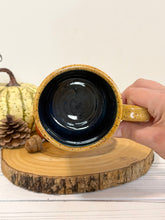 Load image into Gallery viewer, #001 - 16 oz. Leaf and acorn patterned speckled mug with burnt yellow rim and dark blue inside
