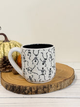Load image into Gallery viewer, #004 - 16 oz. Skeleton patterned white speckled mug with black inside
