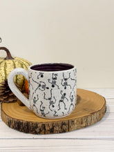 Load image into Gallery viewer, #005 - 14 oz. Skeleton patterned white speckled mug with dark purple inside
