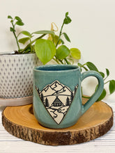 Load image into Gallery viewer, #022 - 16 oz. Mountain Cabin mug with green glaze (pattern on bare clay) and blue inside
