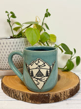 Load image into Gallery viewer, #022 - 16 oz. Mountain Cabin mug with green glaze (pattern on bare clay) and blue inside
