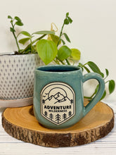 Load image into Gallery viewer, #024 - 16 oz. Adventure wilderness mug with green glaze (pattern on bare clay) and blue inside
