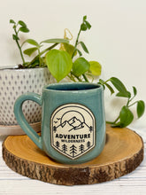 Load image into Gallery viewer, #024 - 16 oz. Adventure wilderness mug with green glaze (pattern on bare clay) and blue inside
