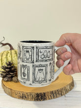 Load image into Gallery viewer, #003 - 16 oz. White speckled mug with Halloween ghost patterns. Black inside.
